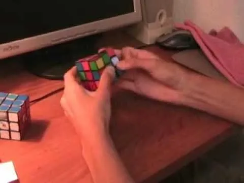 Person solving a Rubik's Cube at a desk.