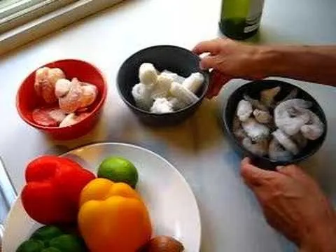 Fresh seafood and colorful bell peppers on a kitchen countertop.