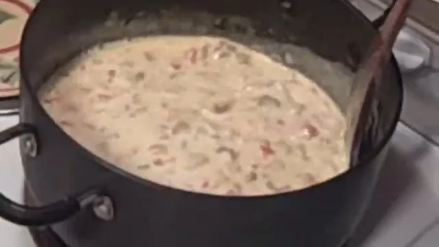 Creamy soup simmering in a black pot.