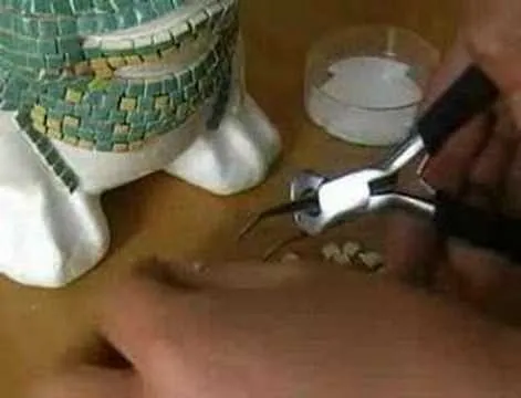 Handcrafted mosaic repair in progress, with tools and pieces nearby.