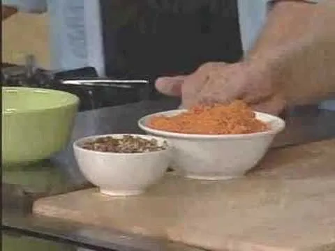 Bowls of spices and shredded carrots on a kitchen counter.