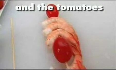 Shrimp and cherry tomatoes on a cutting board.