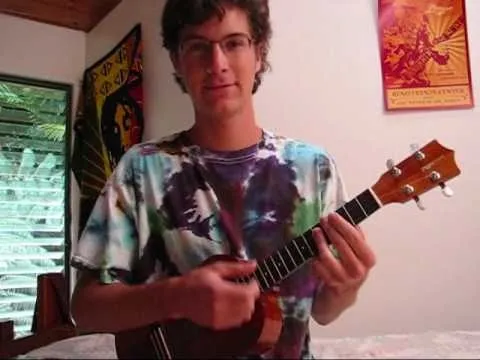 A person playing a ukulele indoors.