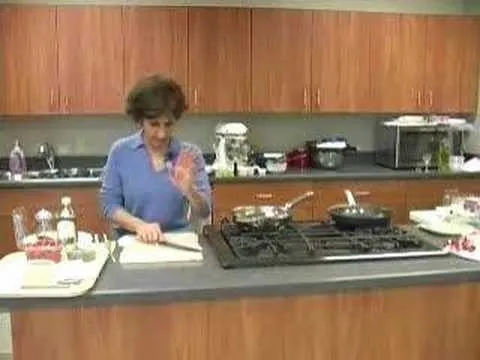 Woman cooking in a modern kitchen with various ingredients and utensils.
