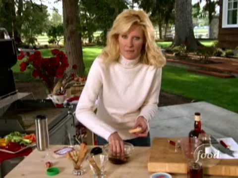 Woman preparing food on an outdoor kitchen table.