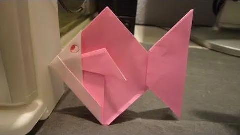 Pink origami butterfly on a flat surface.