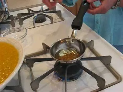 Cooking oil being heated in a small pan on a stove.