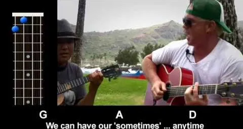 Two musicians playing guitars outdoors, surrounded by nature.