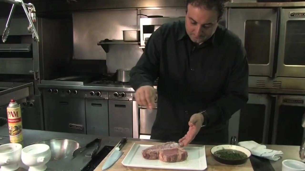Chef preparing meat in a kitchen setting.
