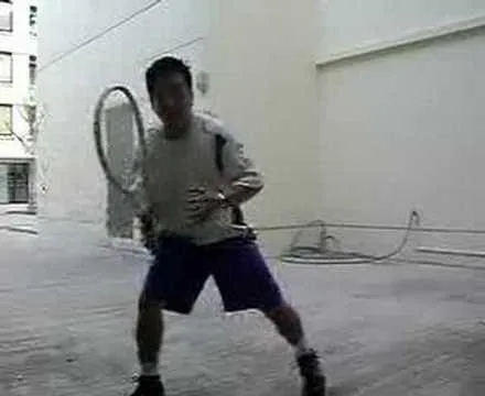 A person preparing to hit a tennis ball in a sports setting.