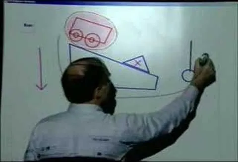 A person drawing a diagram on a whiteboard, illustrating a physics concept.