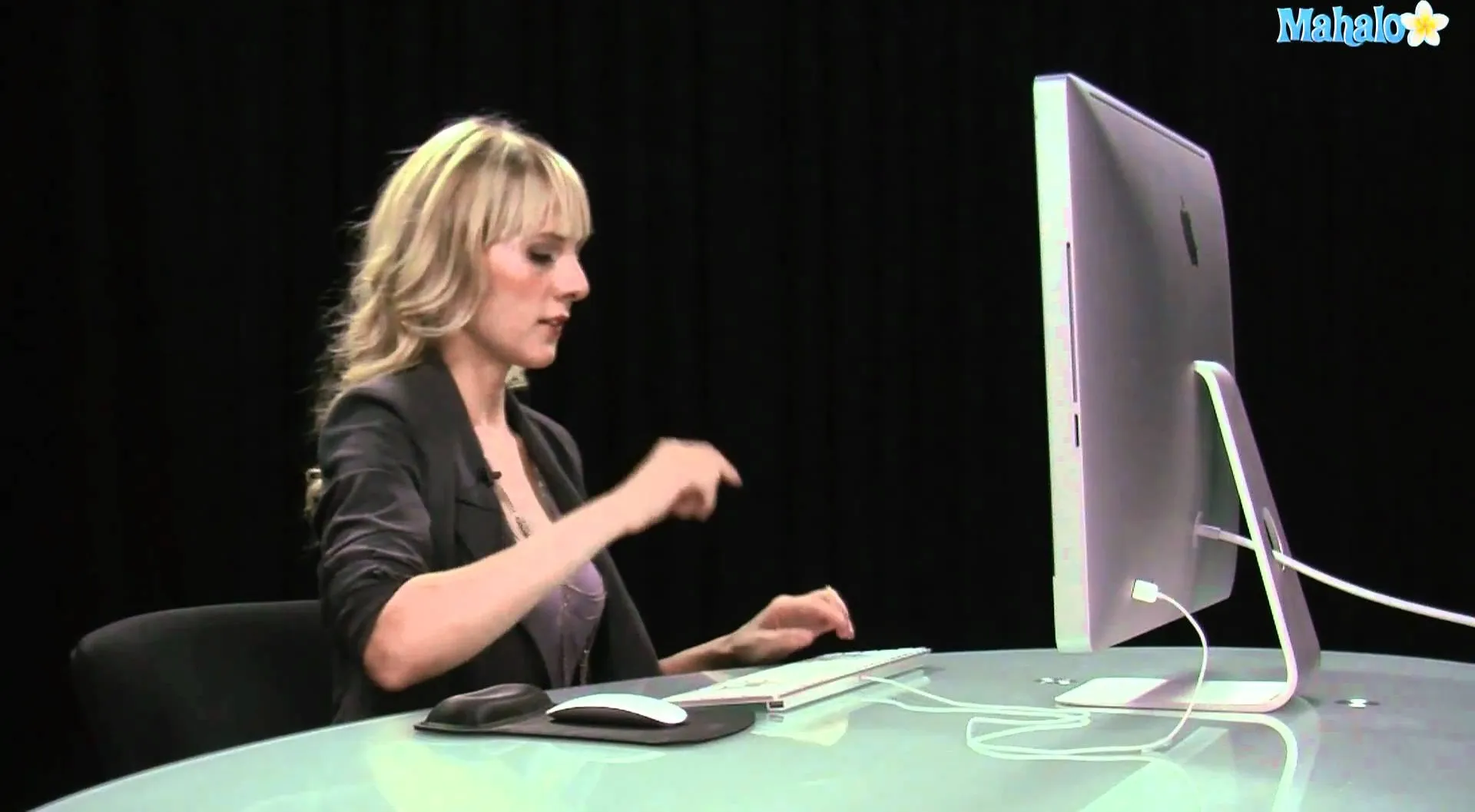 Woman working on a computer at a desk.