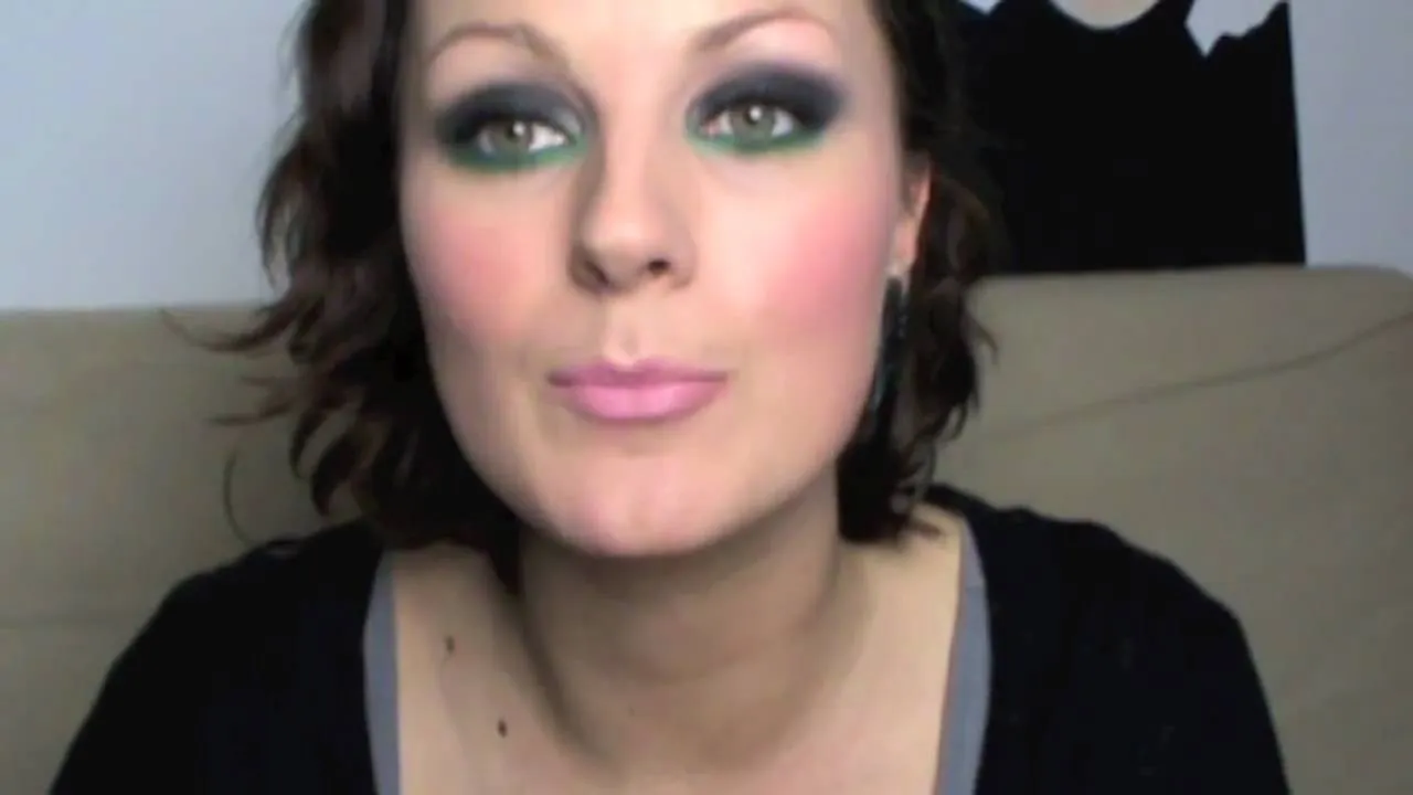 Woman with dramatic eye makeup and light pink lips.