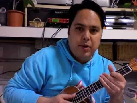A person playing a ukulele indoors.