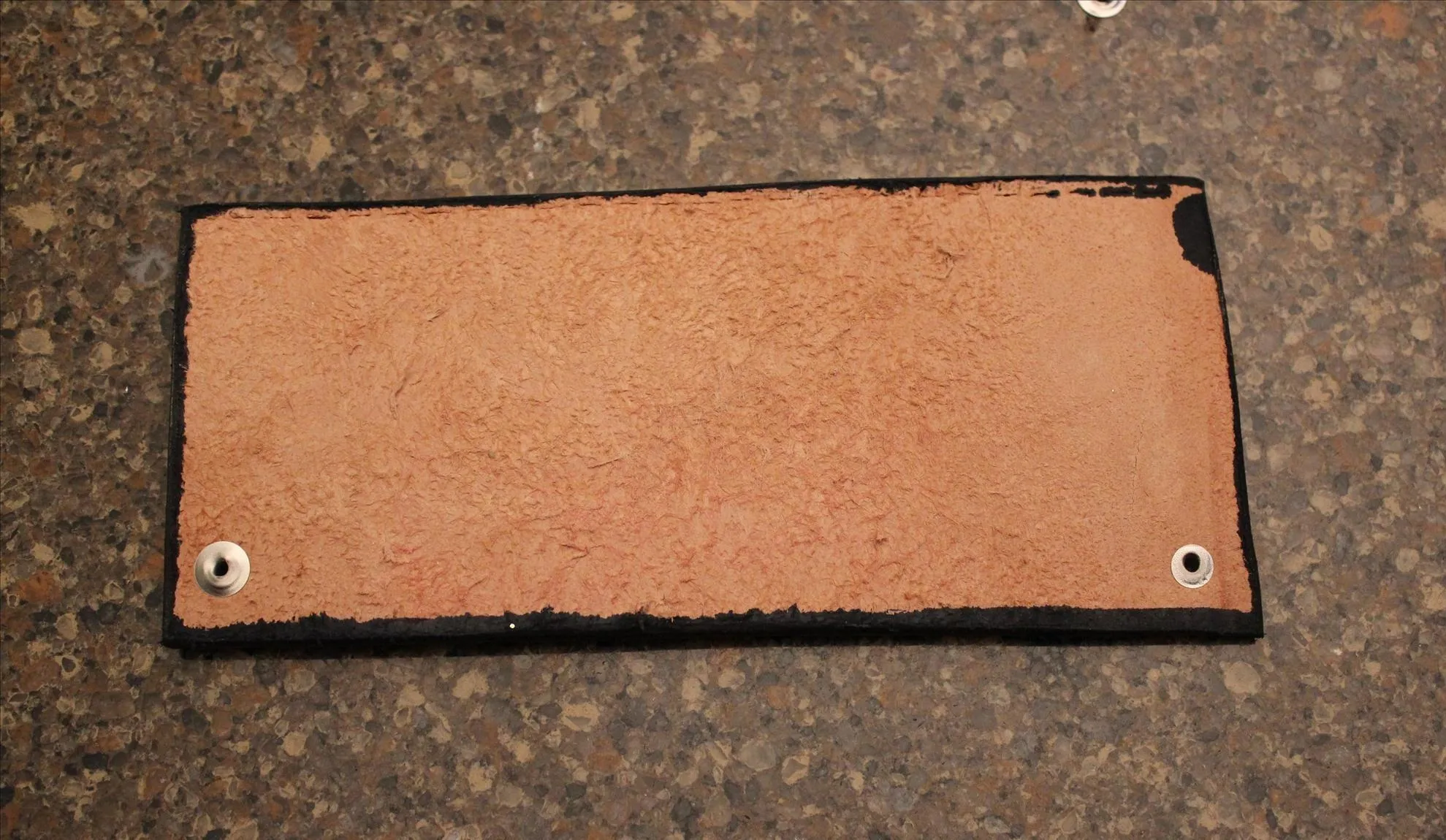 Leather patch on a textured surface.