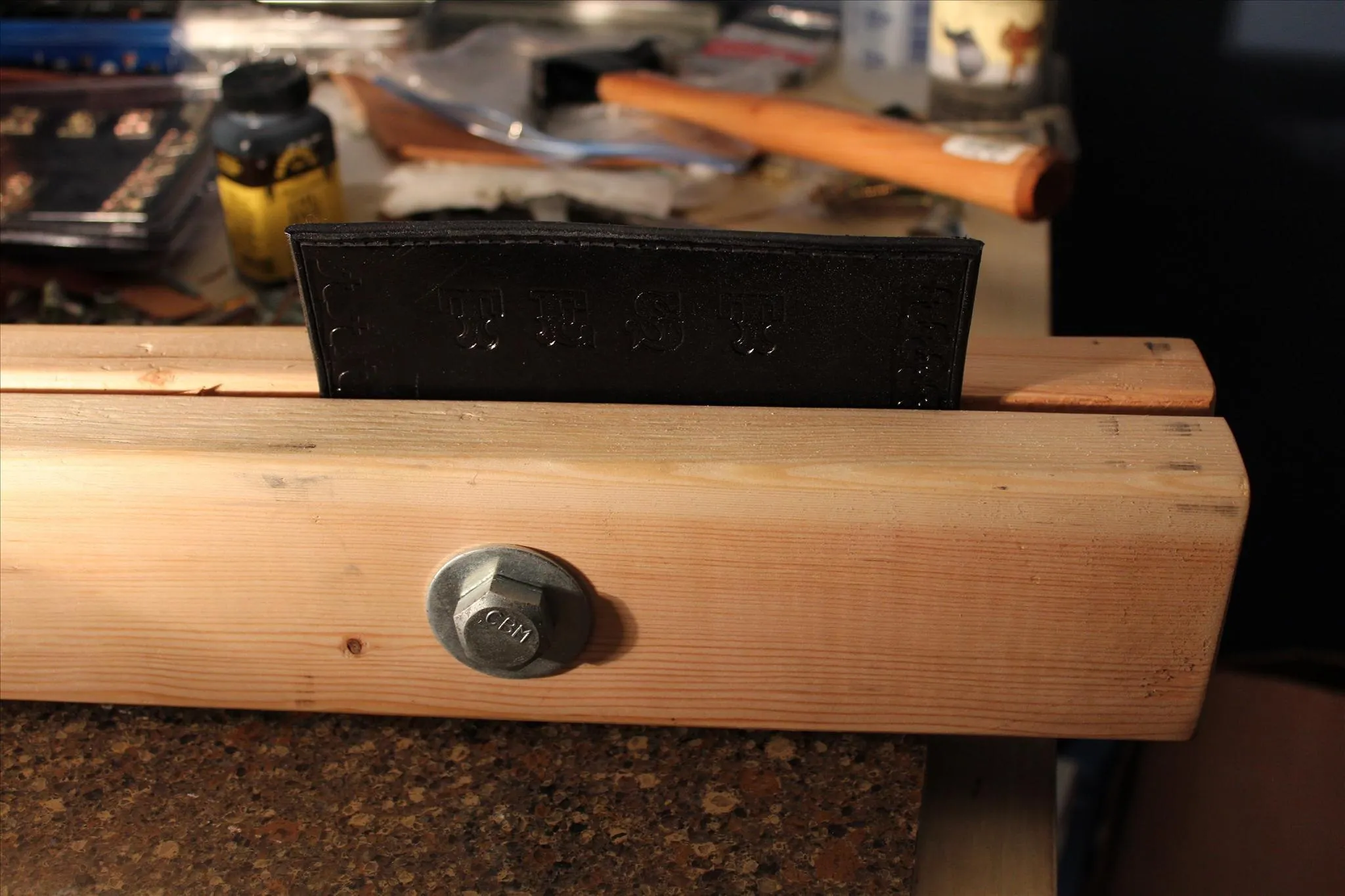 Woodworking tool with a black block on a wooden surface.