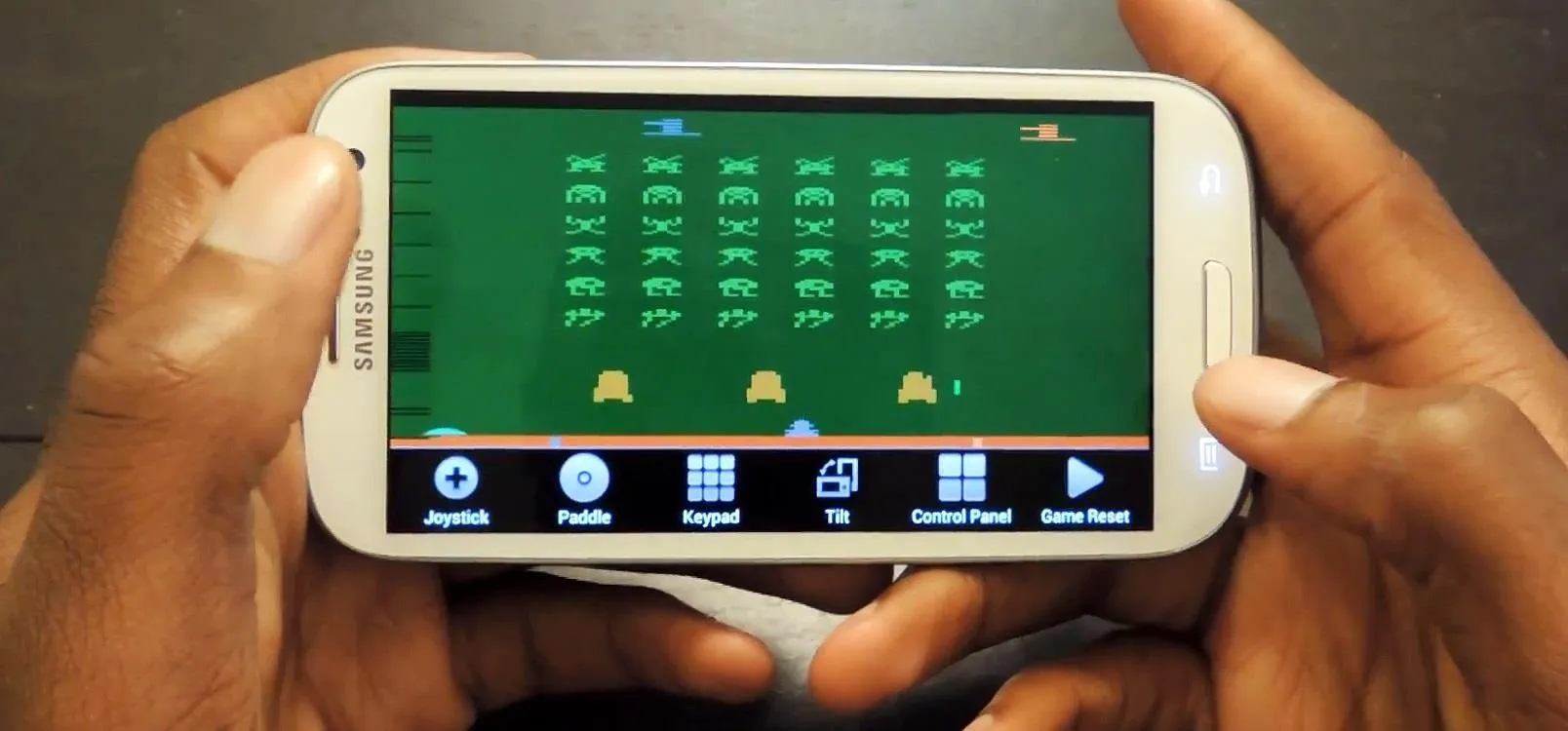 A person playing a retro-style mobile game on a smartphone.