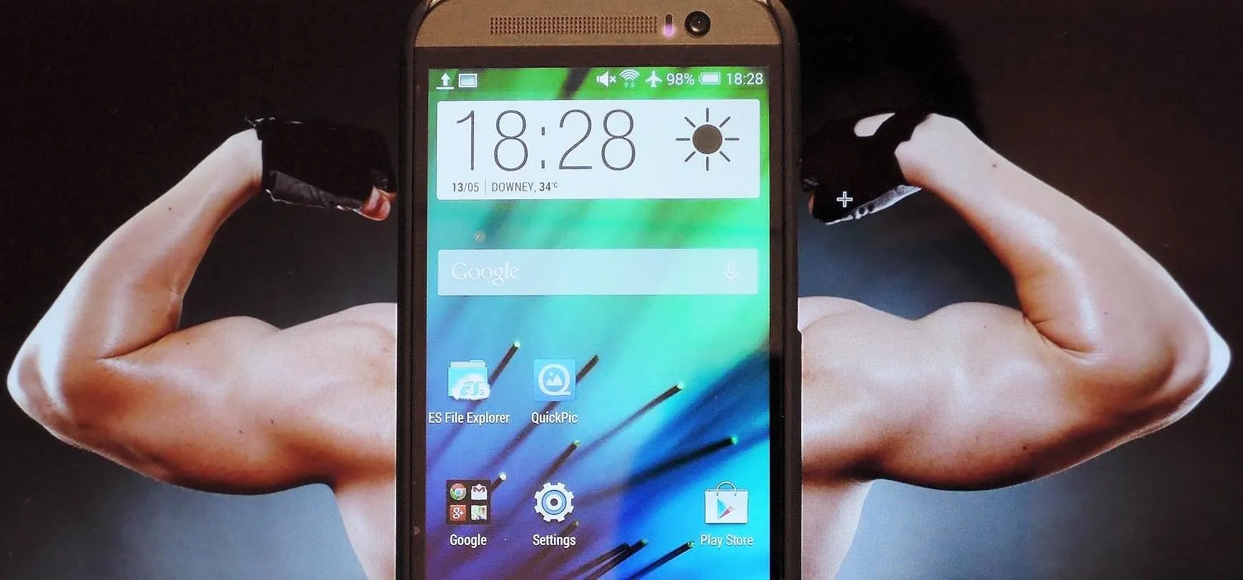 Smartphone displaying time and apps with a muscular background.