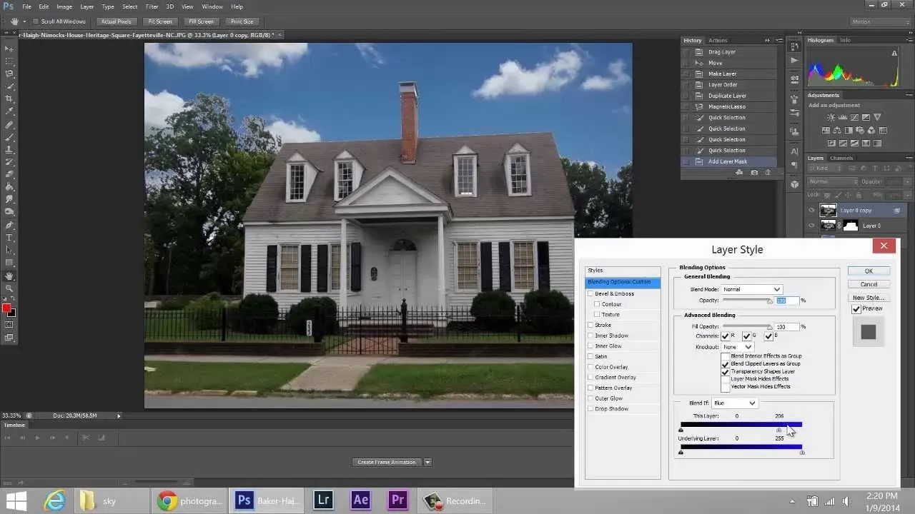 A classic white house with a grey roof and well-manicured lawn, displayed in a photo editing software.