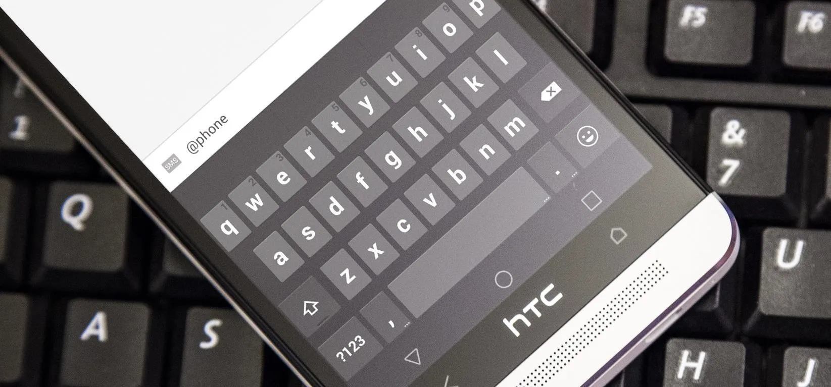 Smartphone keyboard overlaid on a computer keyboard.