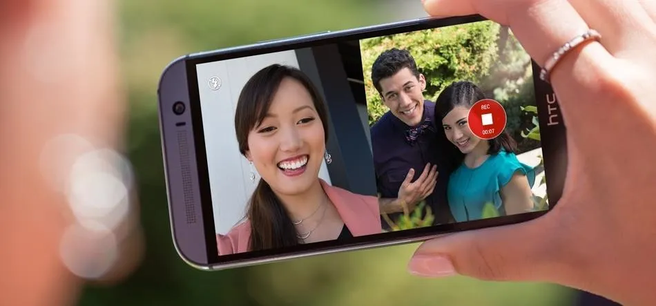 A person taking a selfie with two others outdoors.