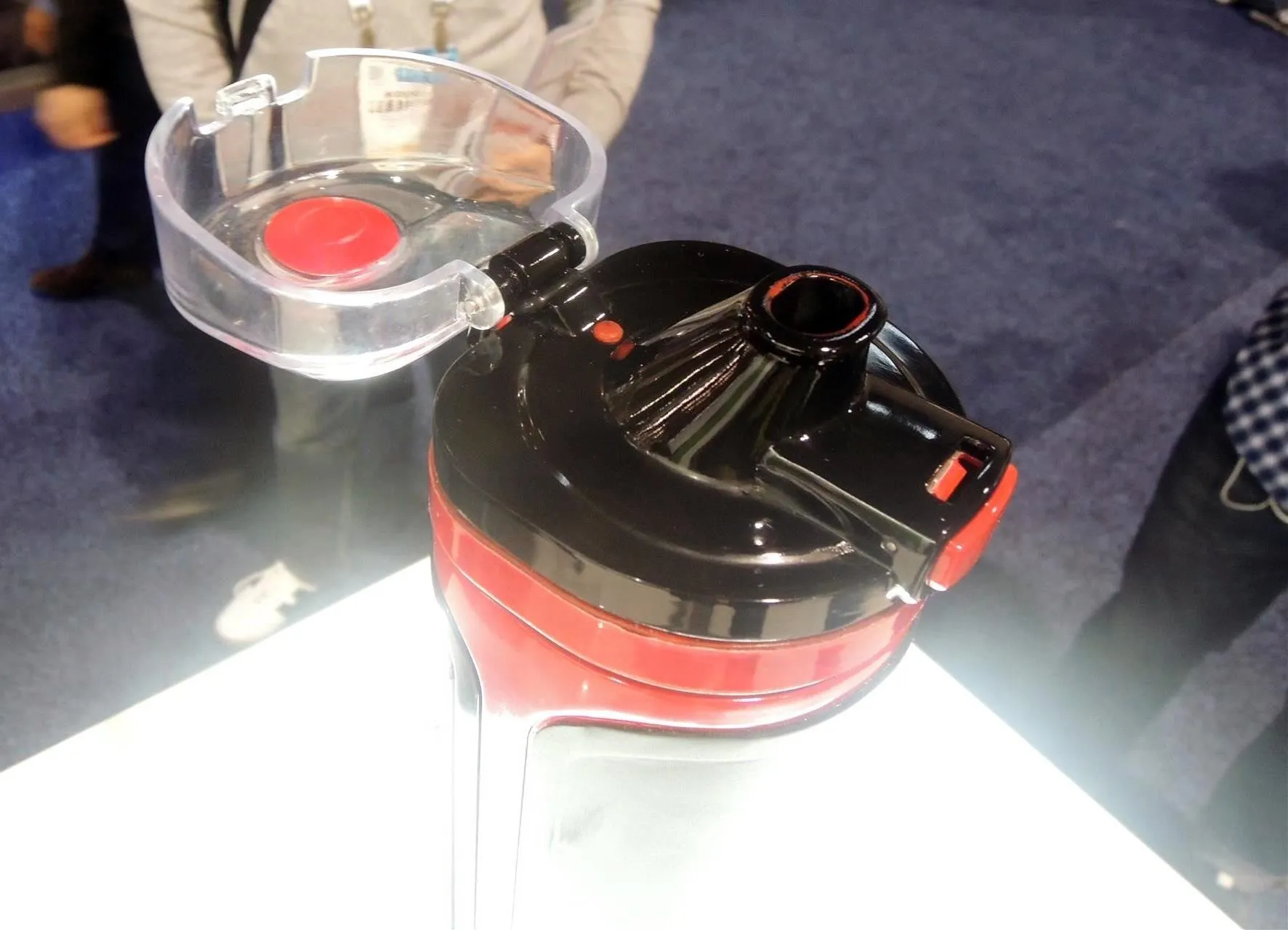Compact kitchen appliance with a transparent lid and red accents.