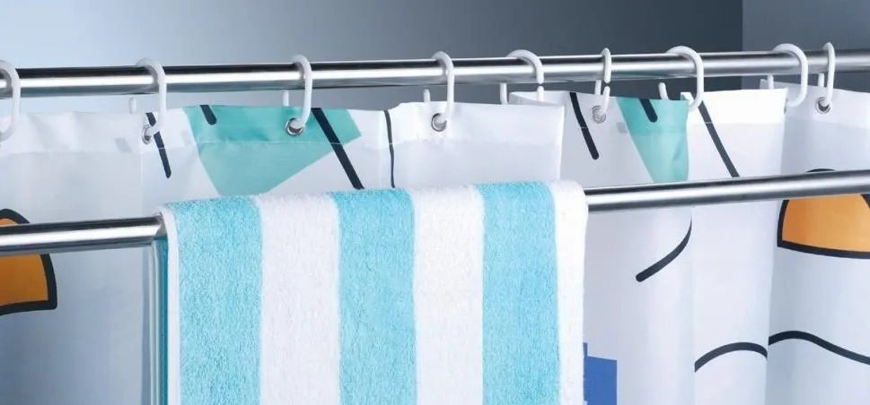 Shower curtain with colorful designs and striped towel.