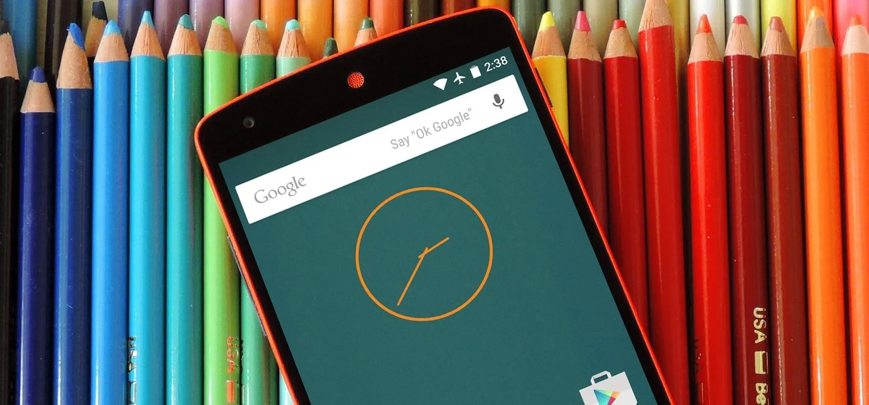 Colorful pencils with a smartphone displaying a clock and search bar.