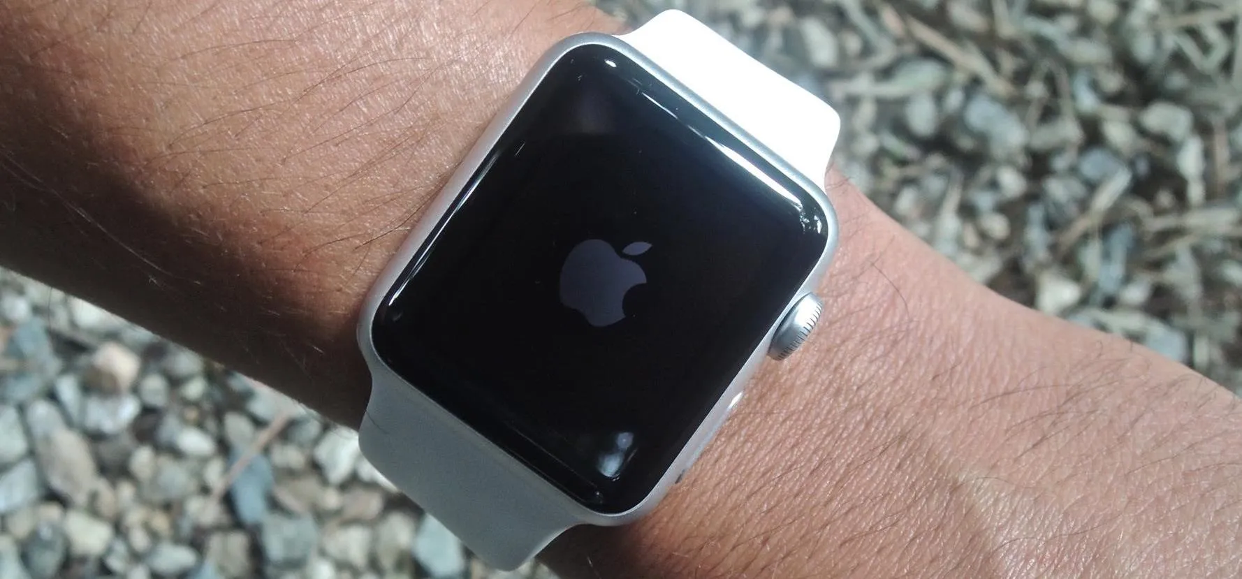 Smartwatch in a sleek white box on a wooden surface.