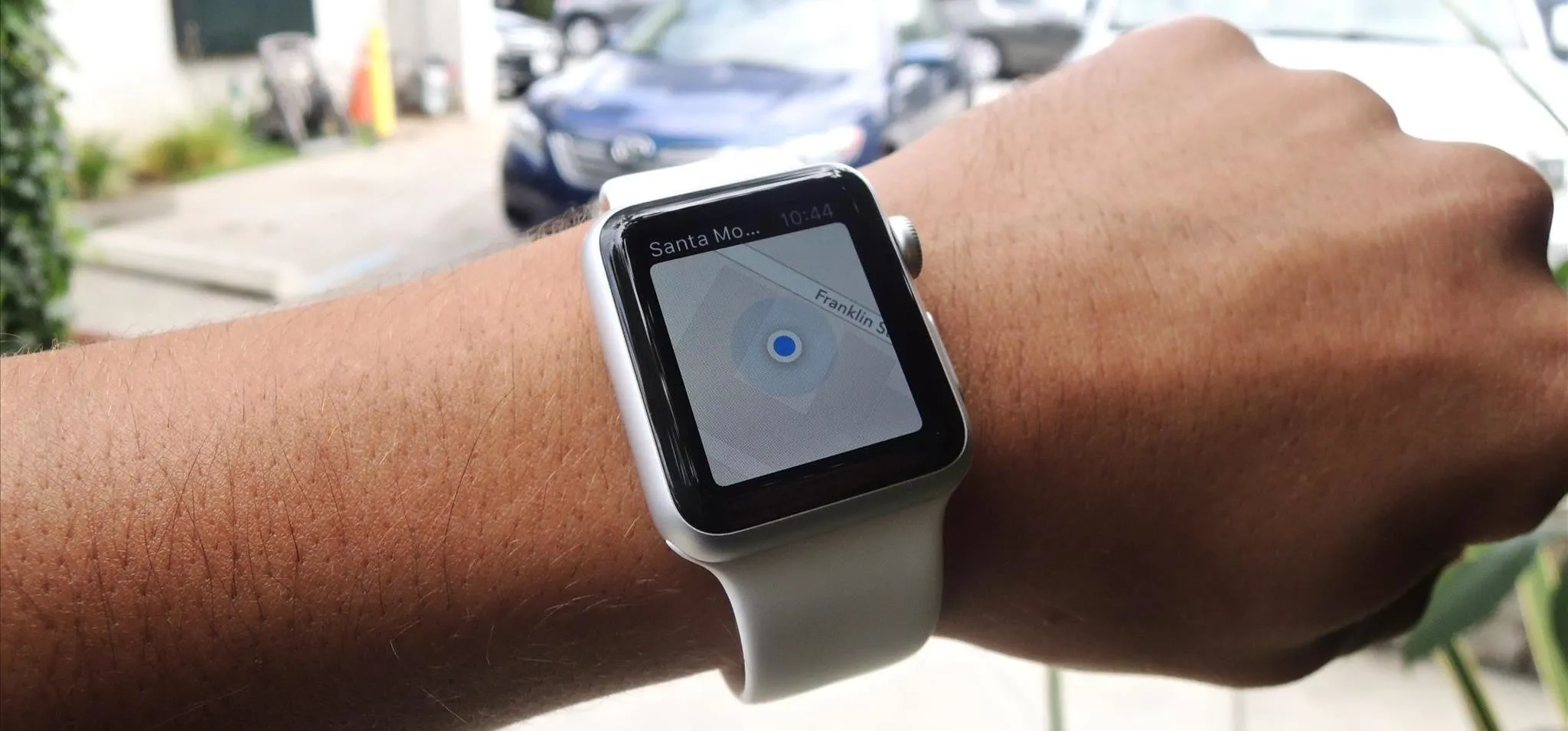 Smartwatch displaying a blue dot on the screen, worn on a wrist.