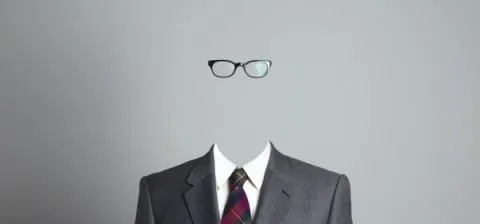 Businessman in a suit with glasses and no visible face.