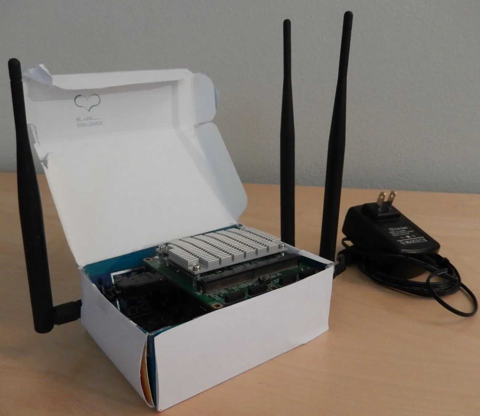 Wireless router in an open box with antennas and power adapter.