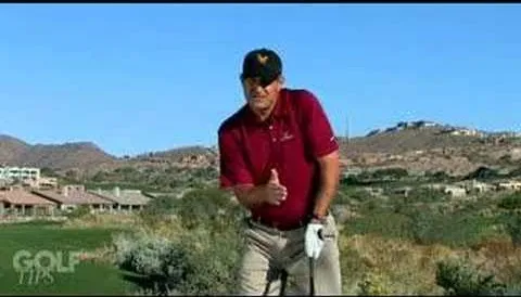 Golfer demonstrating a swing technique on an outdoor course.