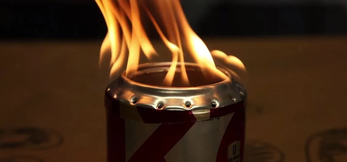 Flaming soda can on a table.