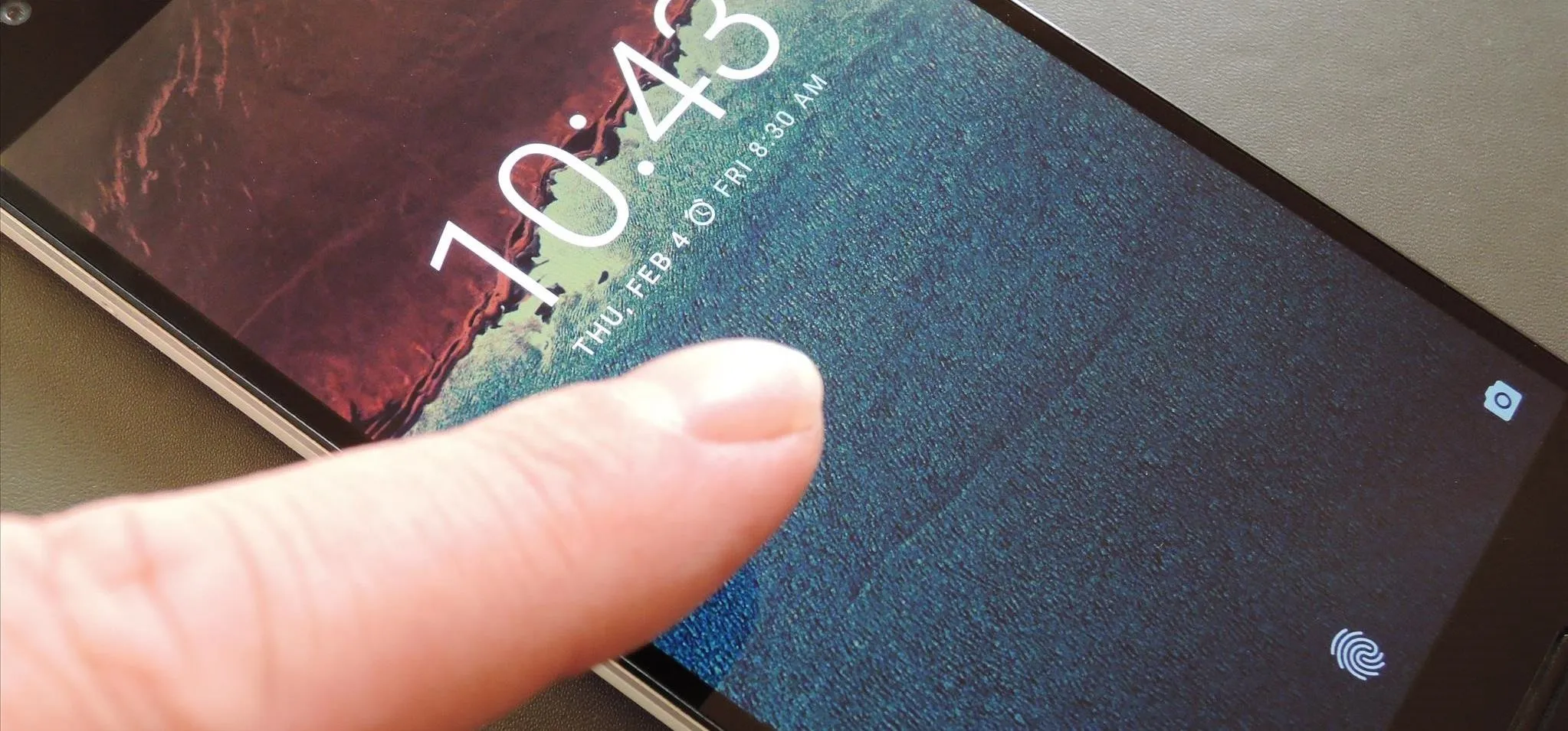 Smartphone screen displaying the time 10:43 with a finger pointing at it.