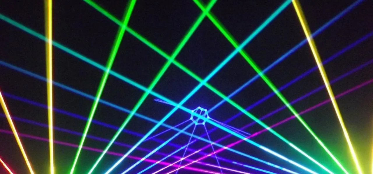 Colorful laser lights forming a geometric pattern in a dark setting.