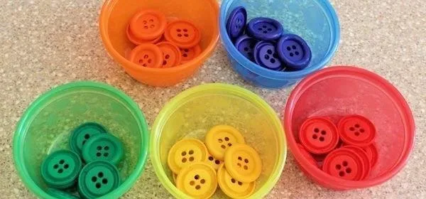 Colorful buttons organized in bowls.