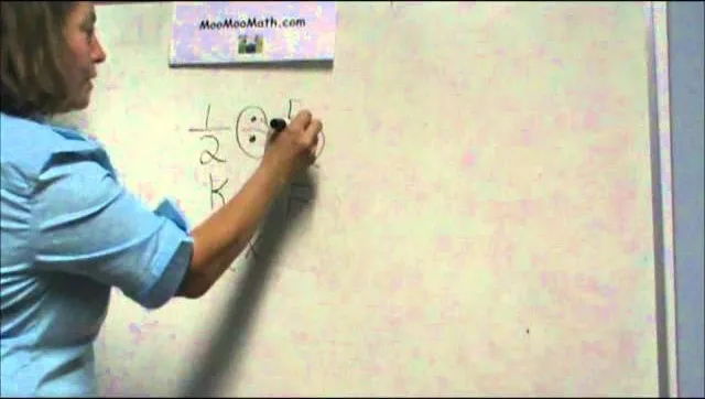 A person writing mathematical equations on a whiteboard.