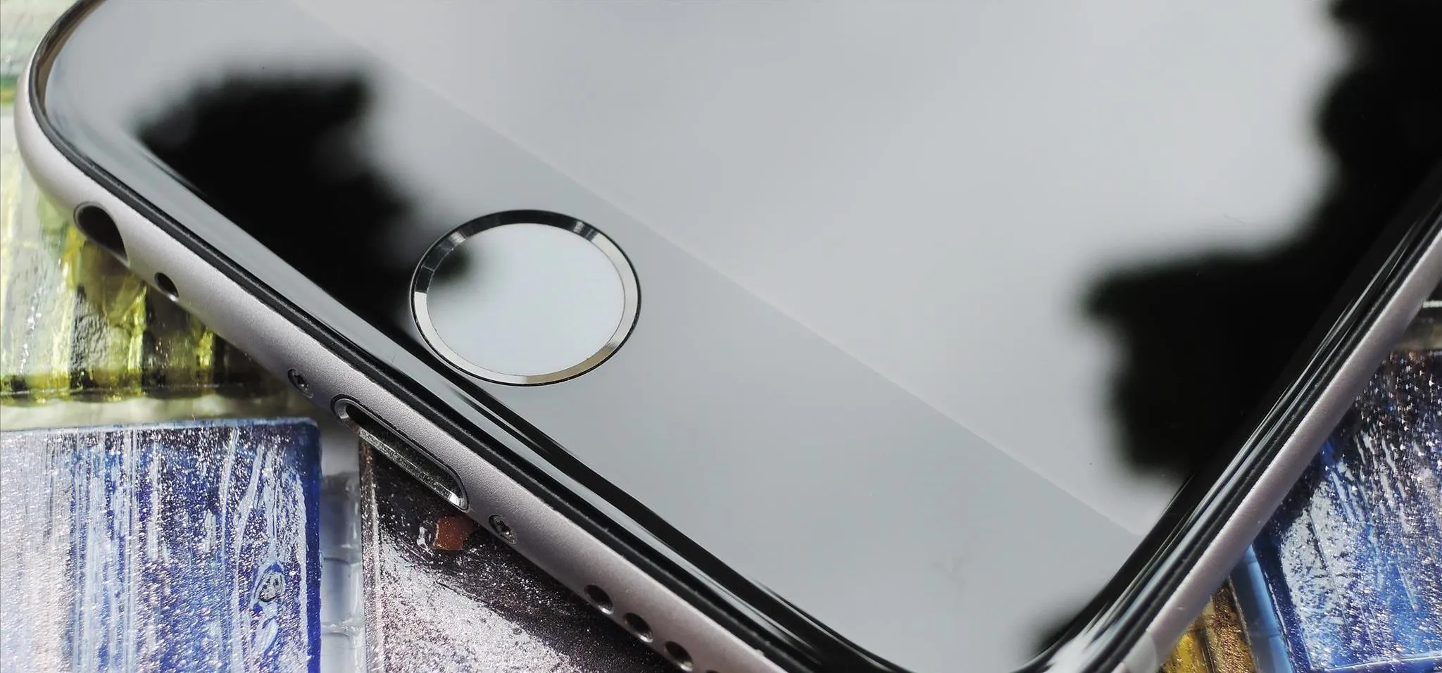 Smartphone display with a fingerprint sensor on a textured surface.