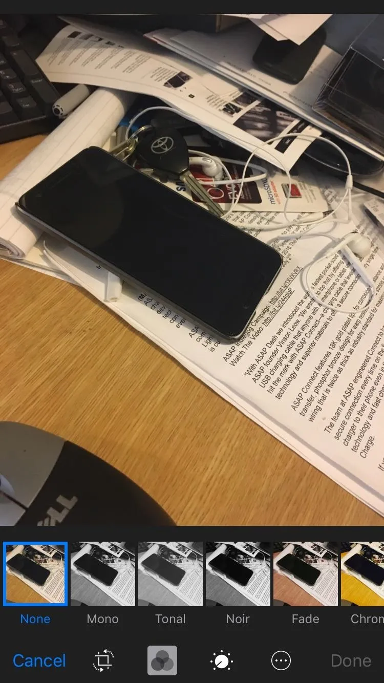 A smartphone placed on a cluttered desk with various items.