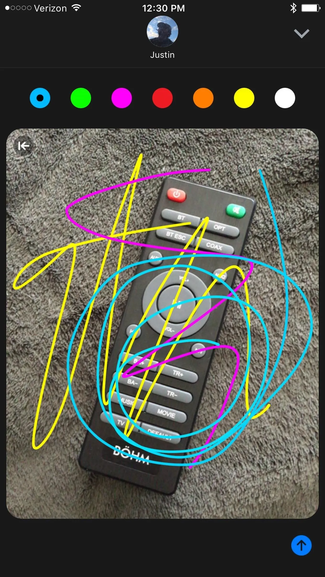 Remote control with colorful doodles on the screen.