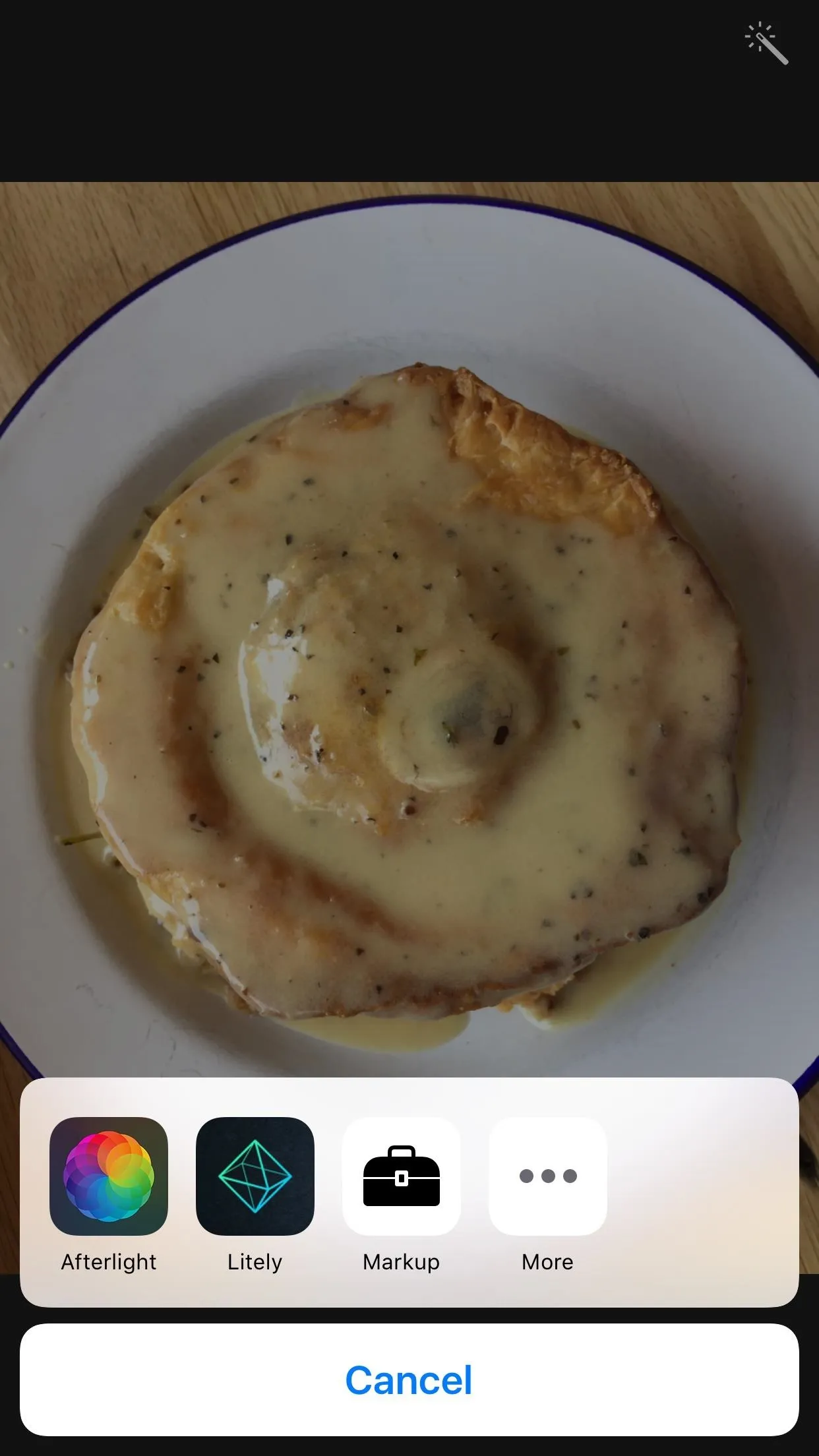 Freshly baked cinnamon roll with icing on a white plate.