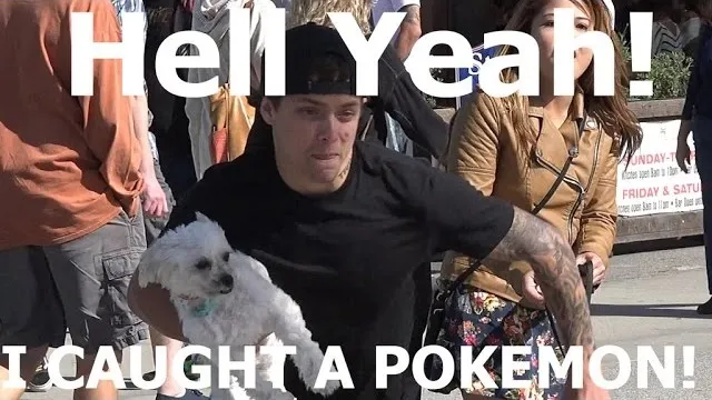 A man celebrating with a small dog while surrounded by people.