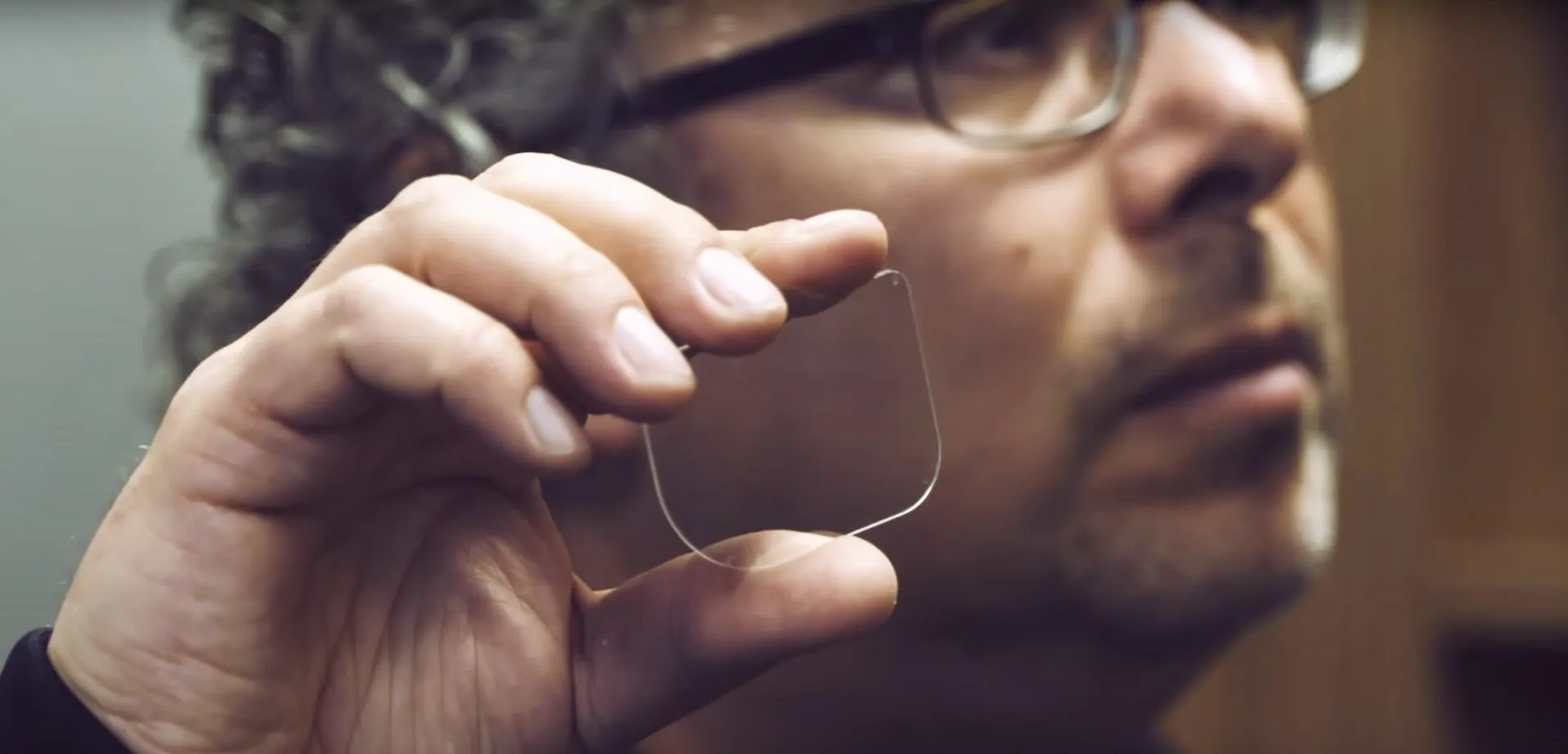 Man holding a thin transparent object.