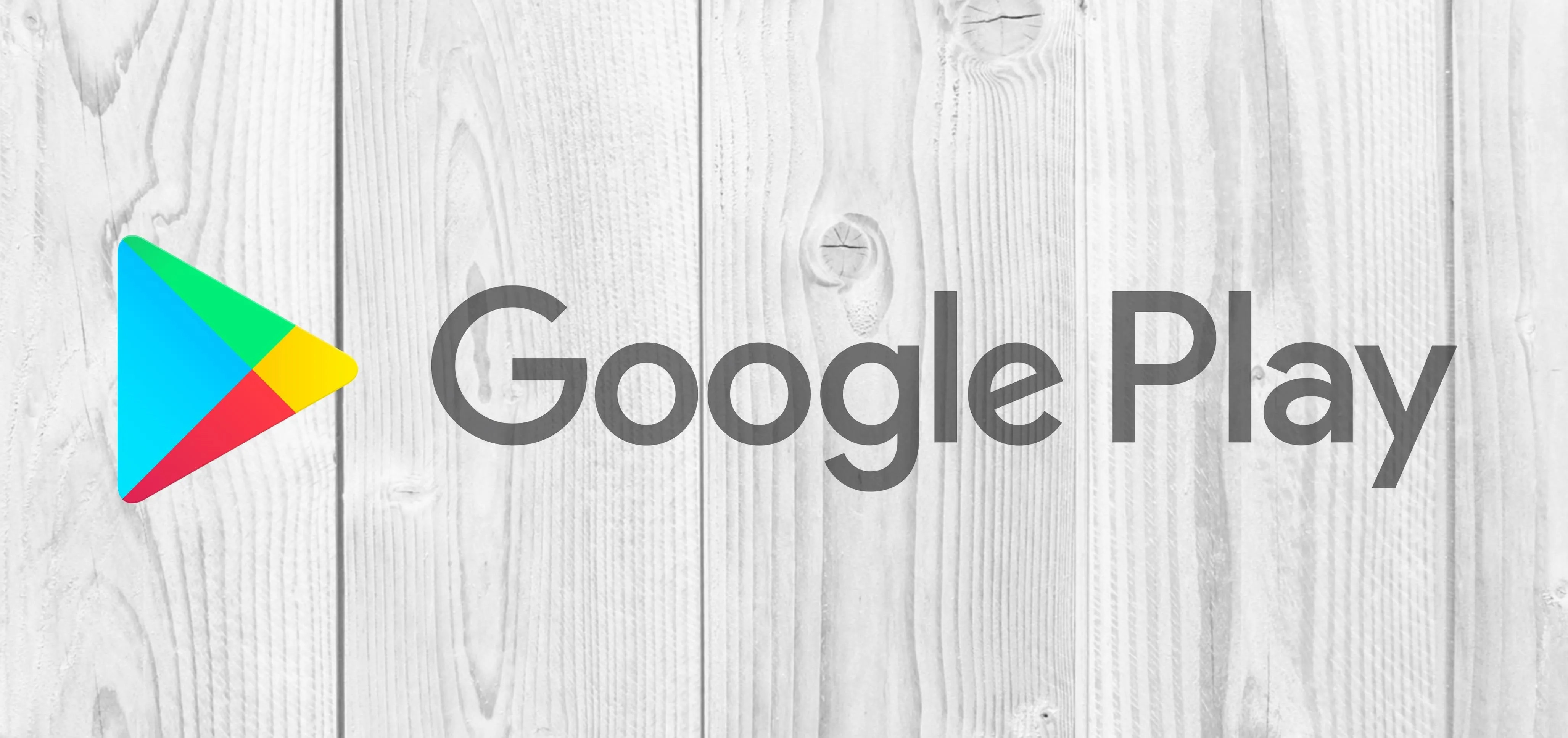 Google Play logo on a wooden background