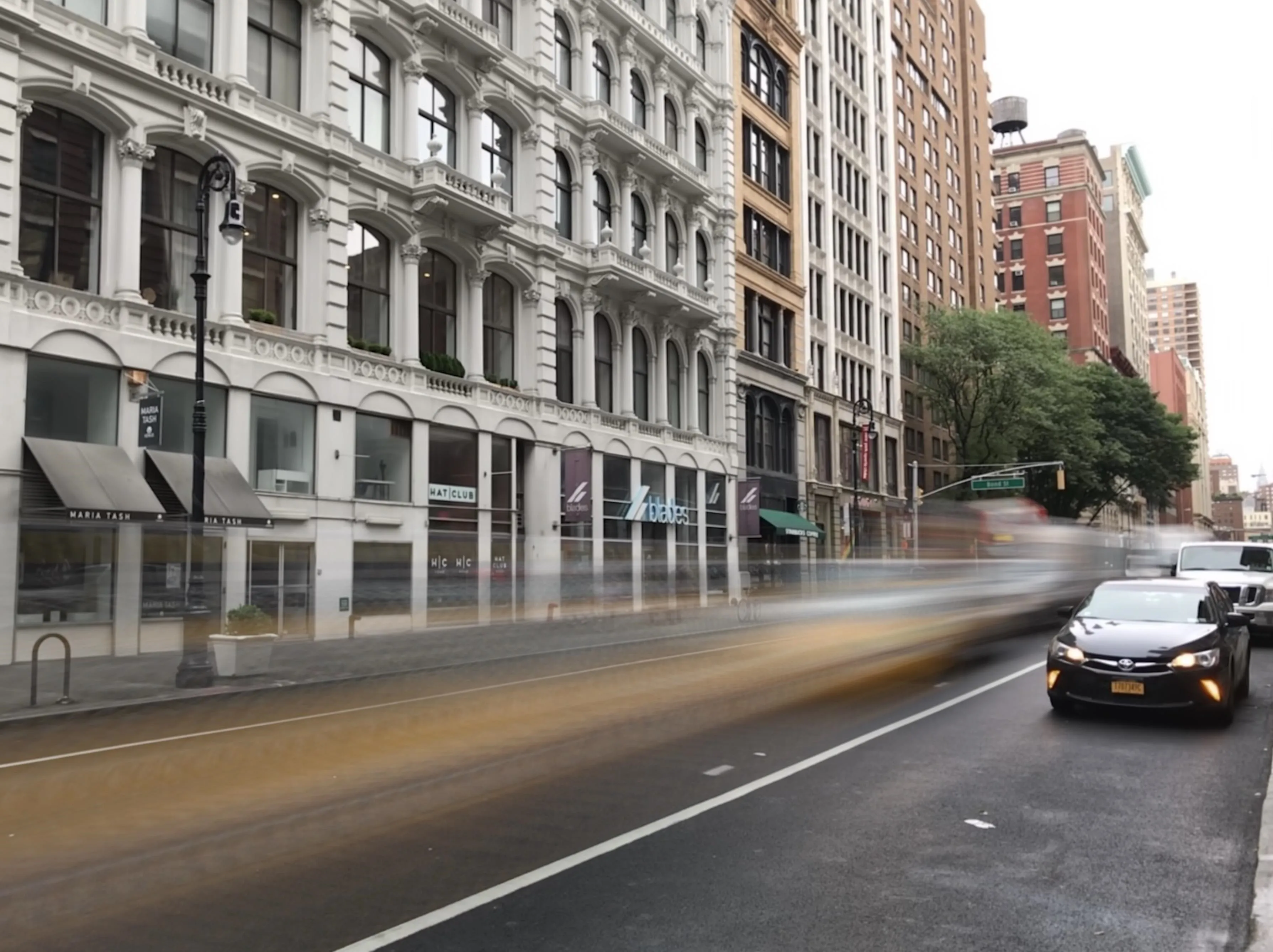 City street with blurred motion of vehicles and historic buildings.