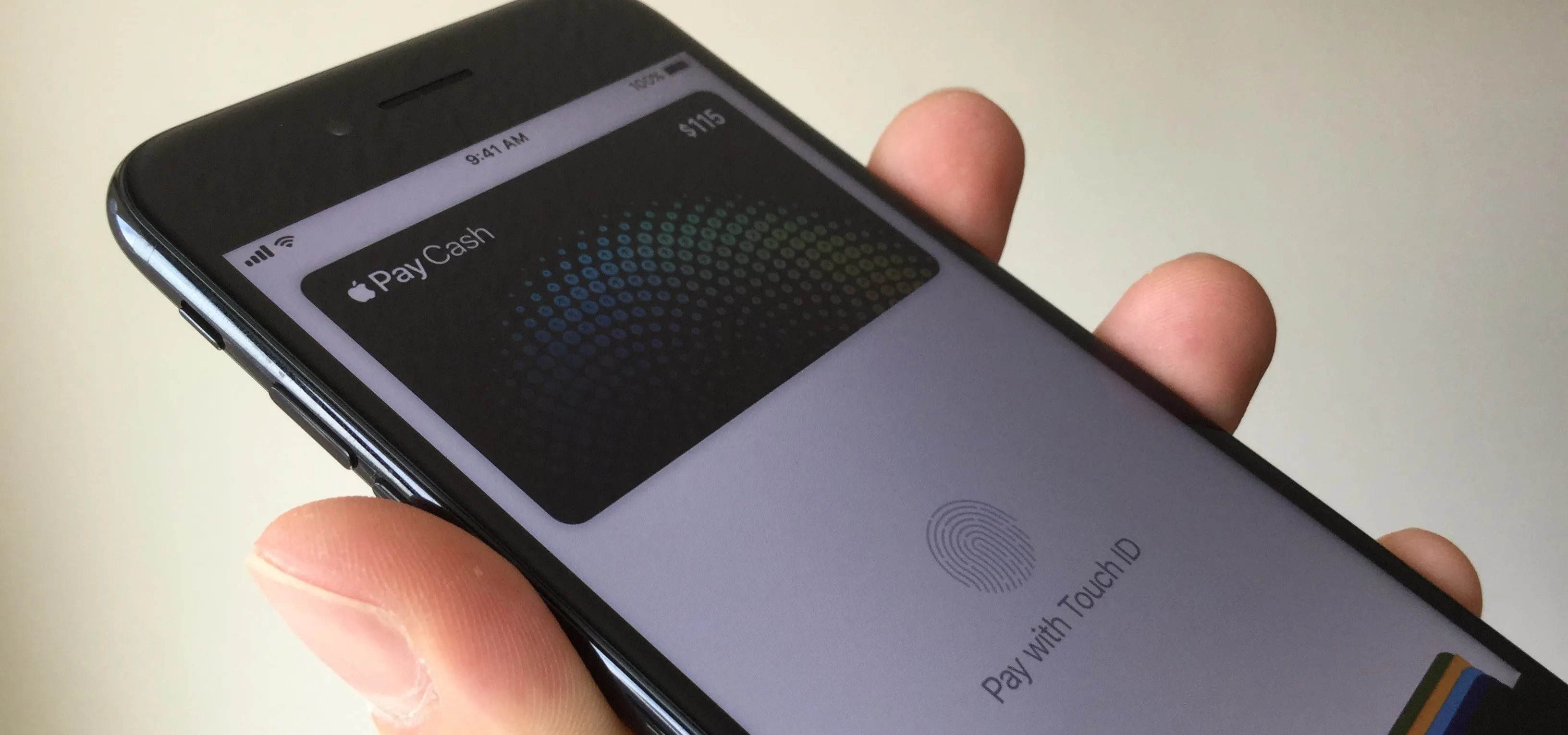 Apple Pay interface on a smartphone held in a hand.