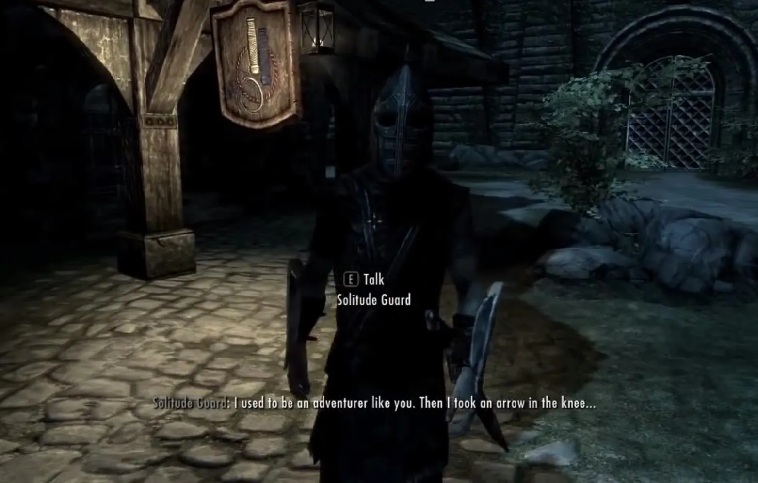 Video game character wearing a helmet, standing in a medieval-themed environment.