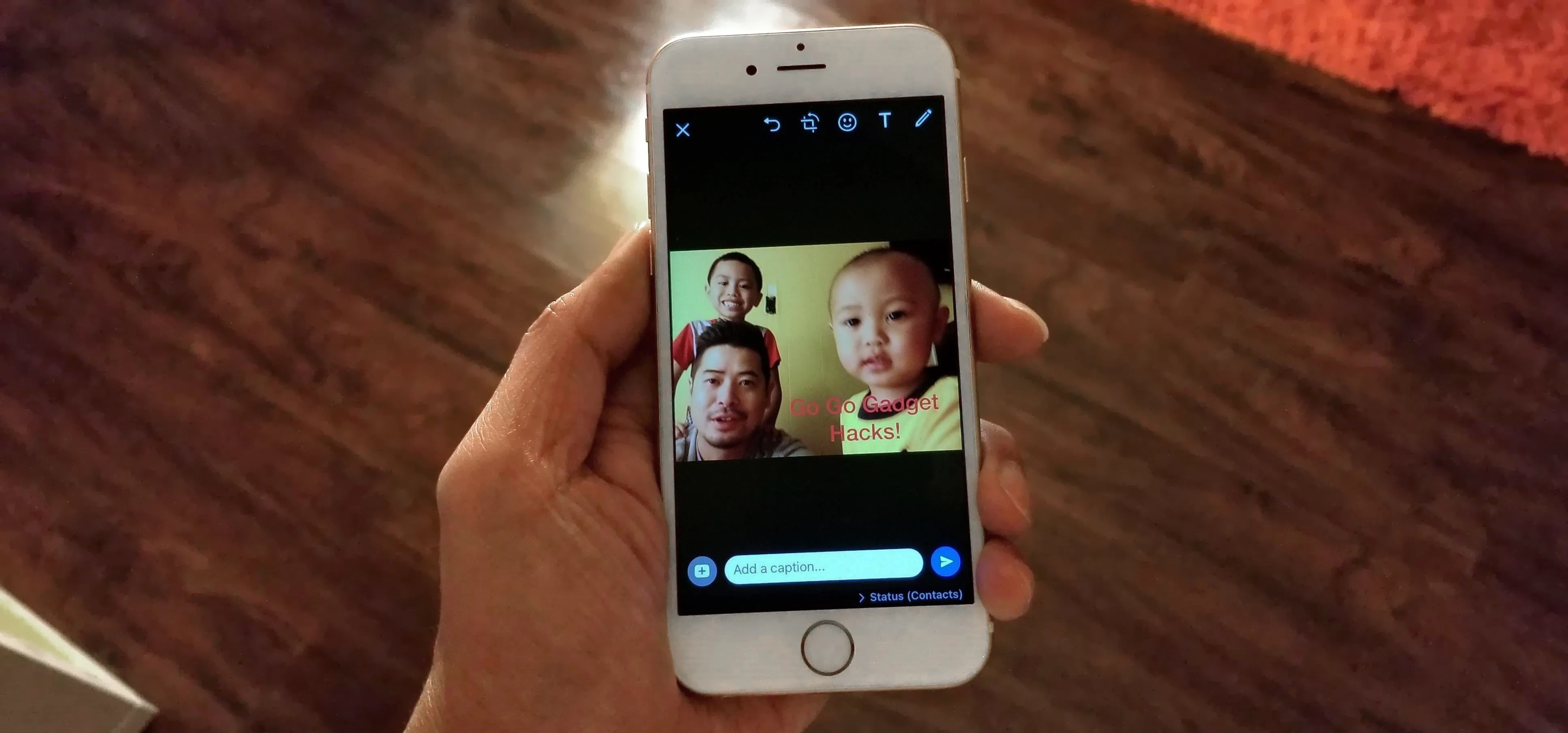 A person holding a smartphone displaying a photo of two children.