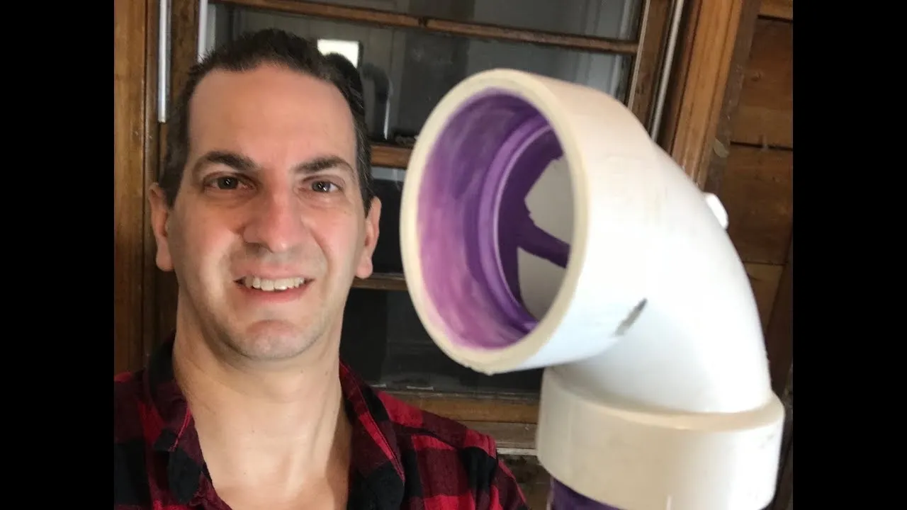 Man holding a white and purple device with a wide opening.